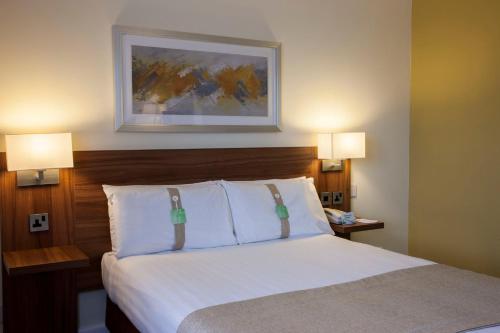 a hotel room with a bed with two lamps on it at Holiday Inn Glasgow - East Kilbride by IHG in East Kilbride