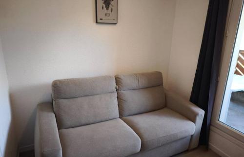 a couch in a living room with a window at studio seignus d allos pieds des pistes in Allos