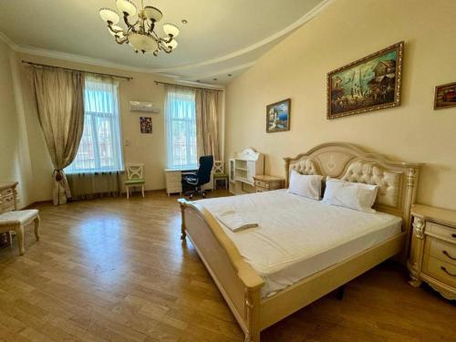 a bedroom with a large bed and a desk at Boomerang Apartments in Odesa