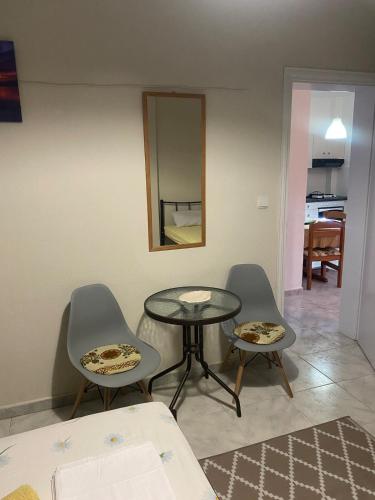 a room with a table and two chairs and a mirror at Evgenia's Apartment Sozopoli in Sozopoli