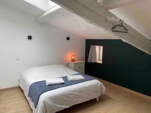 a bedroom with a bed and a green wall at Le Colombier Typique & Proche Pistes cyclables in Belleville-en-Beaujolais