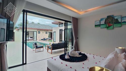 a bedroom with a bed and a view of a pool at Santi Tara Villas in Amphoe Koh Samui
