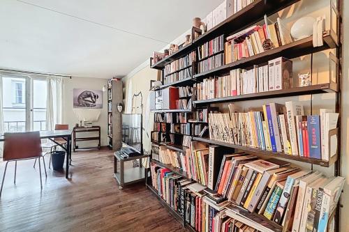 une grande bibliothèque remplie de nombreux livres dans l'établissement Cosy apartment near Bastille, à Paris