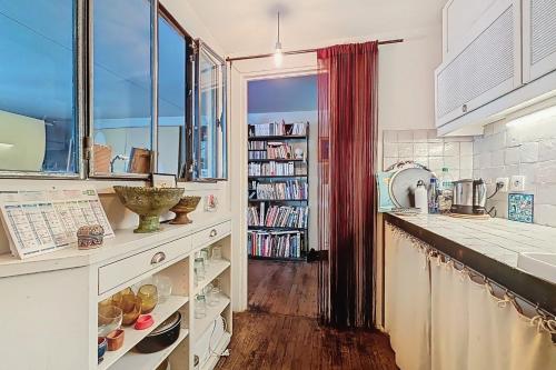 une cuisine avec un comptoir et une étagère. dans l'établissement Cosy apartment near Bastille, à Paris