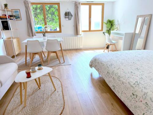 une chambre avec un lit, une table et des chaises dans l'établissement Parenthèse Andernosienne, à Andernos-les-Bains