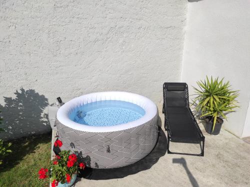 a large bath tub sitting on a patio with flowers at L'escapade in Julos