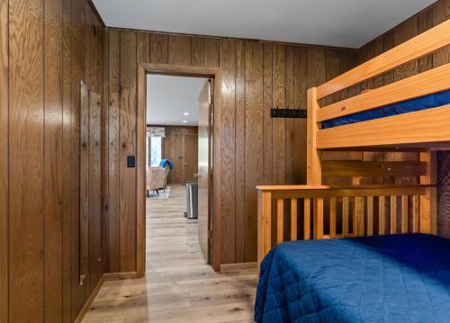 a bedroom with wooden walls and a bunk bed at Twin Oaks B in Mears