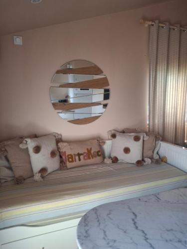 a room with a bench with pillows and a mirror at Dar Fafy studio cosy au calme à 15min de Nantes in Bouguenais