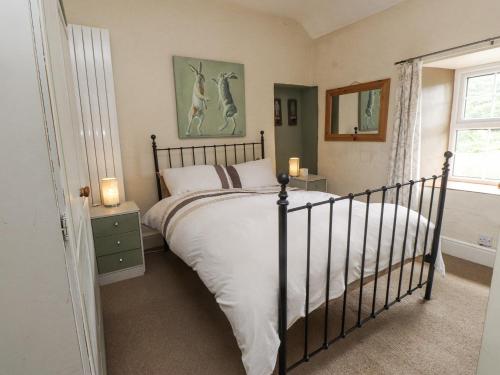 a bedroom with a large bed and a window at Sygun Cottage in Caernarfon
