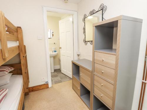 a bedroom with a bunk bed and a closet with a mirror at Sygun Cottage in Caernarfon