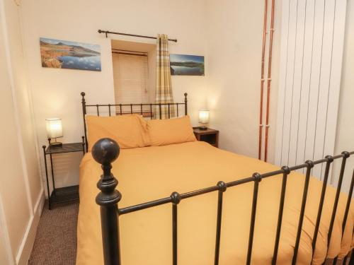 a bedroom with a bed and two night stands at Tryfan Cottage in Caernarfon