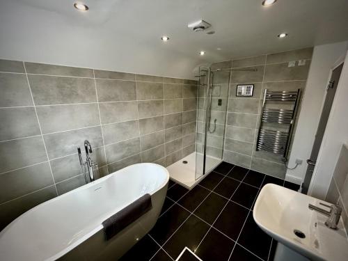 a bathroom with a bath tub and a sink at The Stag Rooms in Stratford-upon-Avon