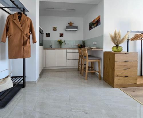 a living room with a table and a coat on a rack at Malu Apartman in Sárvár