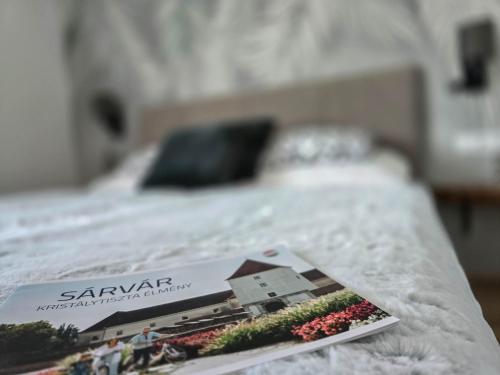 a toy model of a house on a bed at Malu Apartman in Sárvár