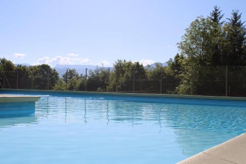 a large swimming pool with blue water at Camping Le Balcon de Chartreuse in Miribel-les-Échelles
