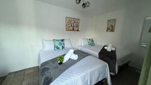 a bedroom with two beds with white sheets at Casa Zakura in Guatemala