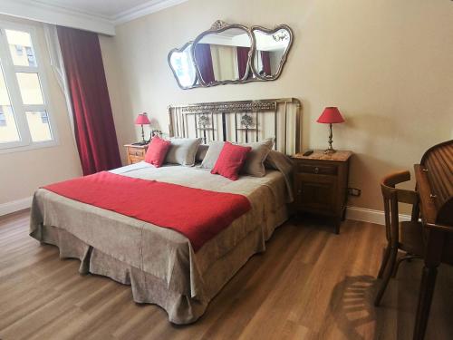 a bedroom with a large bed with a mirror on the wall at Tanguero Hotel Boutique Antique in Buenos Aires