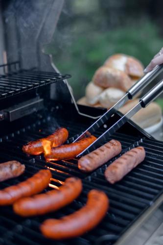 a bunch of sausages and donuts on a grill at Woodland - Terrace - Fire pit - 15min Tremblant in La Conception