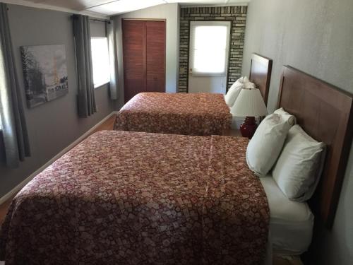 a hotel room with two beds and a lamp at Mountain Trail Lodge and Vacation Rentals in Oakhurst