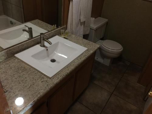 a bathroom with a white sink and a toilet at Mountain Trail Lodge and Vacation Rentals in Oakhurst