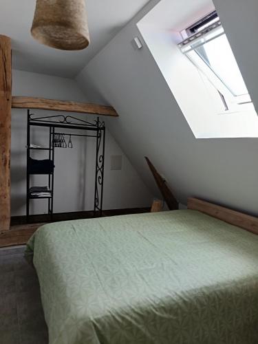 une chambre avec un lit vert et une fenêtre dans l'établissement Ferme de la Dalbeine, à Veuzain-sur-Loire
