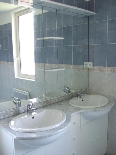 une salle de bain avec deux lavabos et un miroir dans l'établissement Gite le pigeonnier du figue-haut avec piscine privée à durfort lacapelette, à Durfort