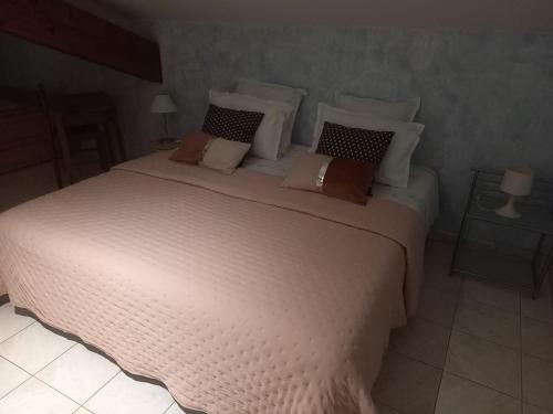 une chambre avec un grand lit blanc avec des oreillers dans l'établissement Gite le pigeonnier du figue-haut avec piscine privée à durfort lacapelette, à Durfort