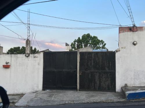 a black gate in the side of a white wall at Casa Zakura in Guatemala