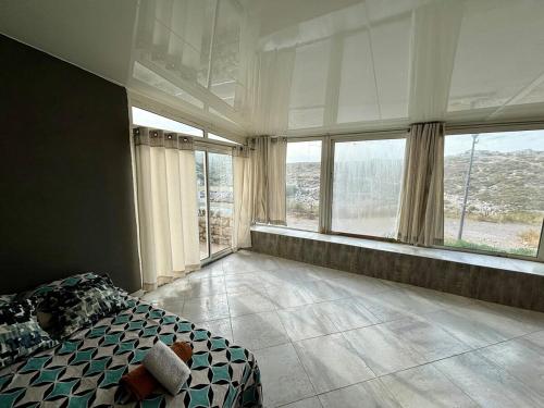- une chambre avec un lit et de grandes fenêtres avec vue dans l'établissement Une parenthèse sur l'eau, à Marseille