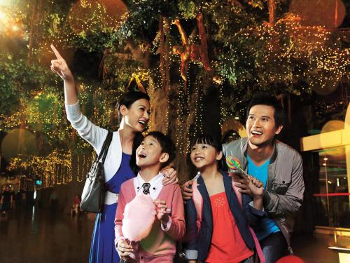 a family standing in front of a christmas tree at Resorts World Genting - First World Hotel in Genting Highlands