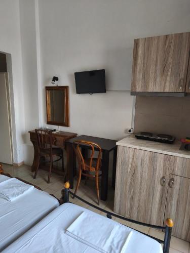 a room with a bed and a table and a desk at Themis - Θέμις Apart Hotel in Loutra Edipsou
