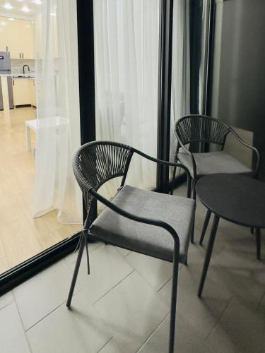 two chairs and a table in front of a window at Tsikhisdziri Apt Sleeps 5 in Tsikhisdziri