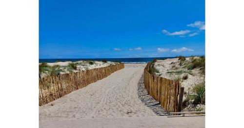 une clôture en bois sur la plage près de l'océan dans l'établissement Appartement bord de mer, à Le Castellas