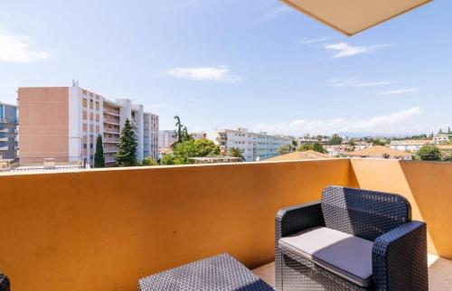 d'un balcon avec une chaise et une vue sur la ville. dans l'établissement CERES- Juan les Pins - 200m des plages, 4pers, wifi, ,clim, parking, à Juan-les-Pins