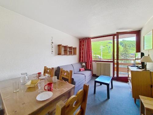 un salon avec une table et un canapé dans l'établissement Appartement lumineux au centre, balcon, proche pistes et commerces - FR-1-344-946, aux Menuires