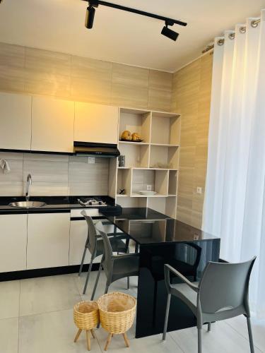 a kitchen with a black island and chairs in a room at Green View in Ponta do Ouro