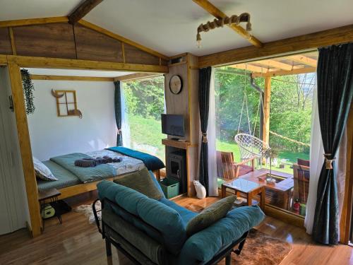 1 dormitorio con 1 cama y sala de estar con ventana en Cabana Mura, 