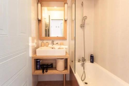 une salle de bain avec un lavabo, une baignoire et un miroir dans l'établissement MISTRAL-Rare 6 pers, parking, wifi, ,clim, piscines, à Antibes