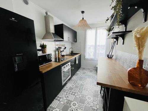 Il comprend une cuisine dotée de carrelage noir et blanc. dans l'établissement Le cocon de Saint Mart'inn, à Brest