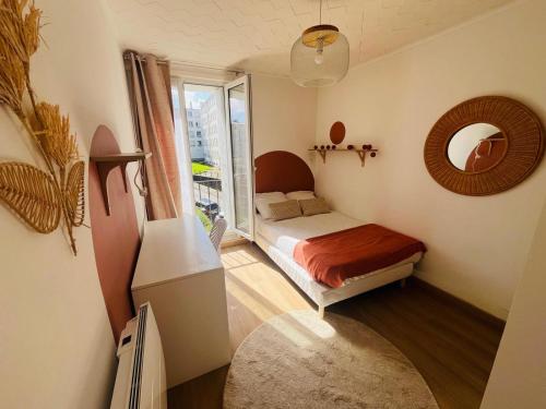une petite chambre avec un lit et un miroir dans l'établissement Le cocon de Saint Mart'inn, à Brest