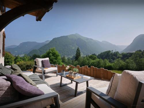un patio avec des canapés et une table avec des montagnes en arrière-plan dans l'établissement Chalet Isla de Lux - OVO Network, à La Côte dʼArbroz