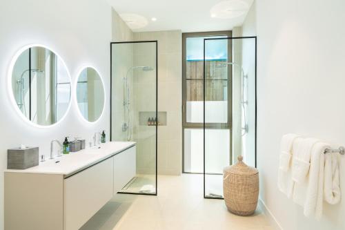 a white bathroom with a sink and a shower at South Bank in Long Bay Hills
