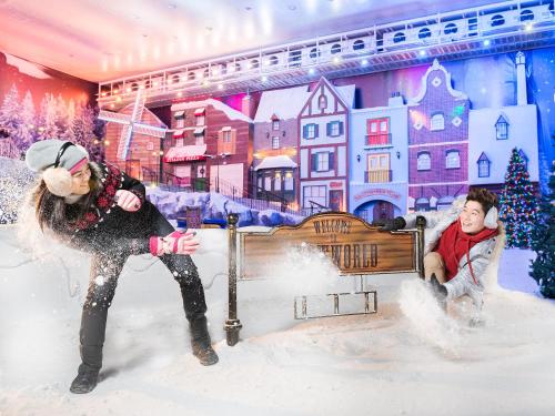 a woman and a man playing in the snow at Resorts World Genting - First World Hotel in Genting Highlands