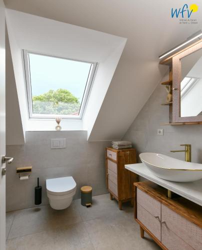 a bathroom with a sink and a toilet and a window at Haus Christine Ferienwohnung 4 in Langeoog