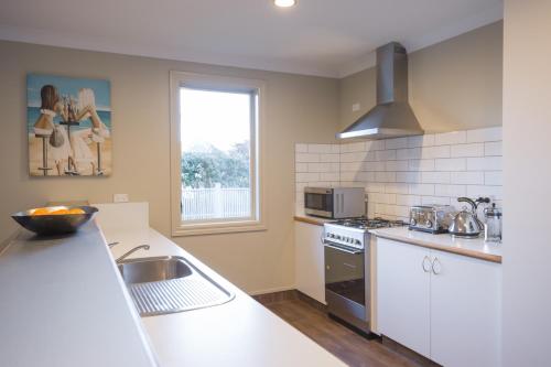 a kitchen with a sink and a stove top oven at The Dairy Hotel Queenstown, A Naumi Chapter in Queenstown