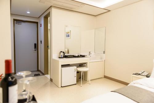 a small bathroom with a sink and a mirror at Rezion Hotel in Seogwipo