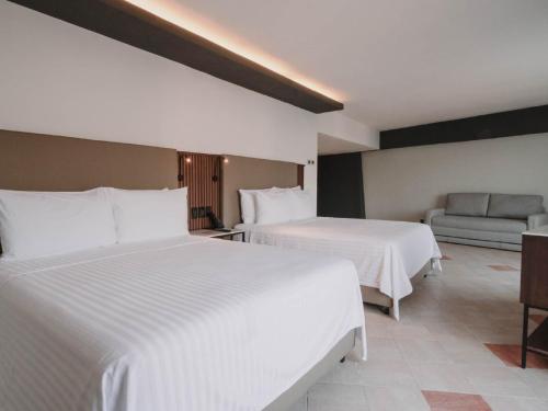 Ένα ή περισσότερα κρεβάτια σε δωμάτιο στο HS HOTSSON Hotel Acapulco