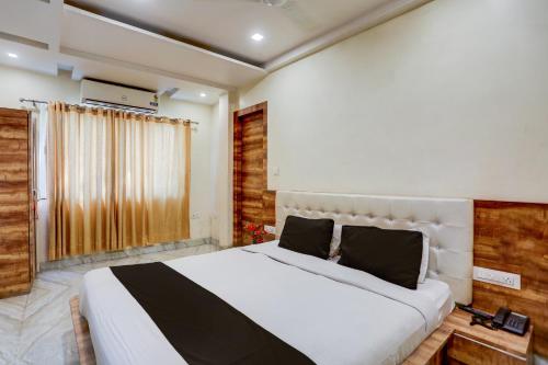 ein Schlafzimmer mit einem großen weißen Bett und einem Fenster in der Unterkunft SPOT ON Sai P Guest House in Varanasi