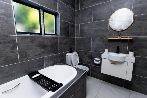 a bathroom with a sink and a bath tub with a phone at Gaborone City Center stay, ultrafast wifi & near CBD & Airport in Joverega