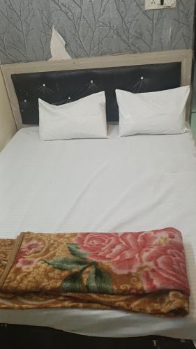 a white bed with a plate of pizza on it at Hotel shree kalyan prime in Kota